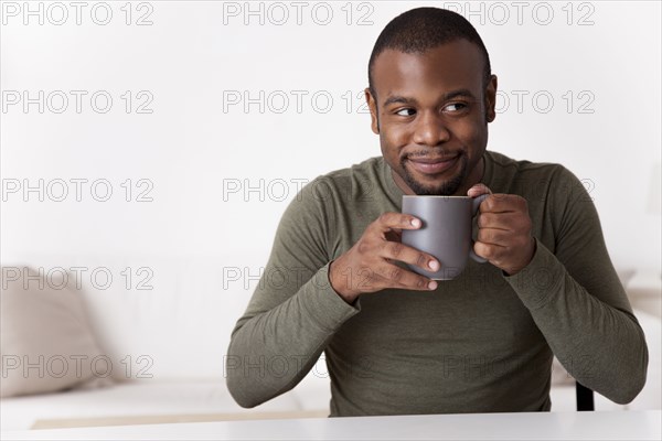 Smiling Black man drinking coffee