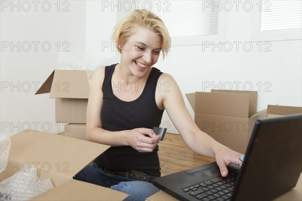 Caucasian woman shopping online in new home