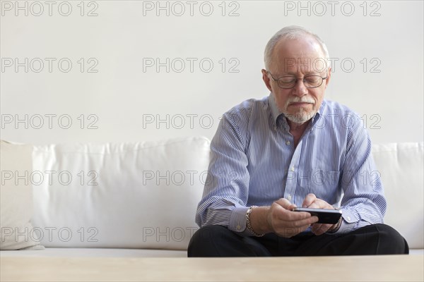 Caucasian man using tablet computer on sofa