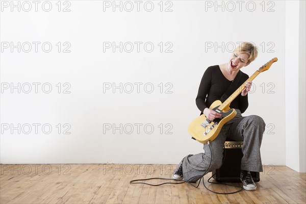 Caucasian woman playing electric guitar