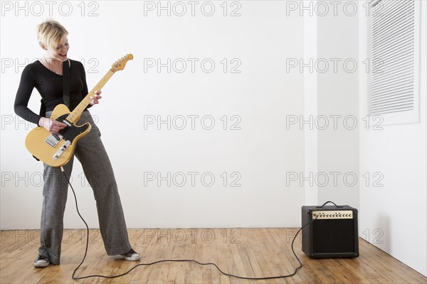 Caucasian woman playing electric guitar