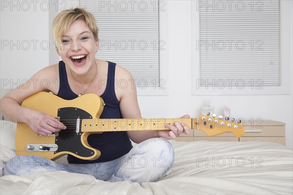 Caucasian woman playing electric guitar