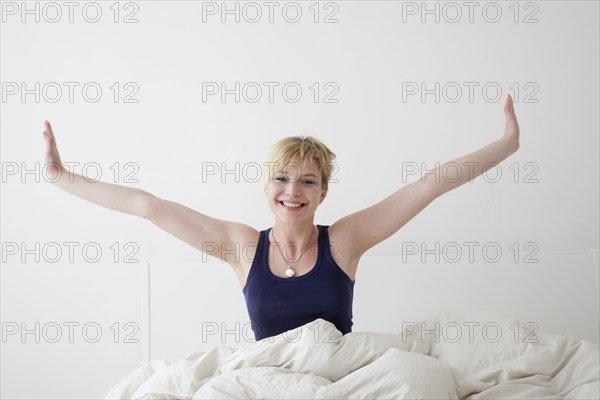 Caucasian woman stretching on bed