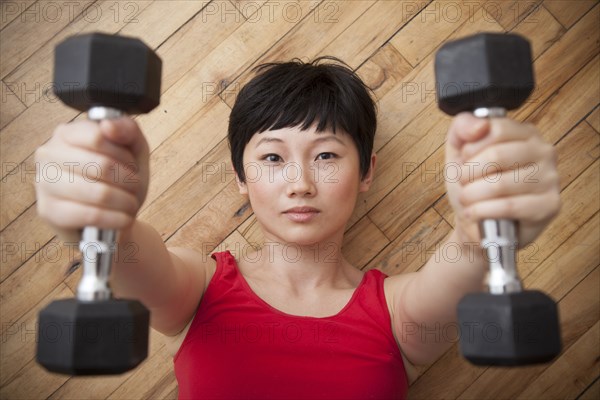 Woman lifting weights on floor