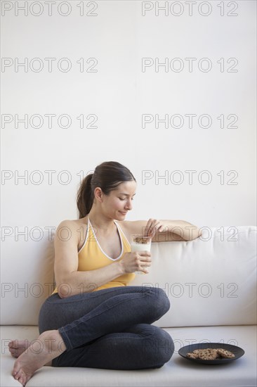 Caucasian woman having milk and cookies