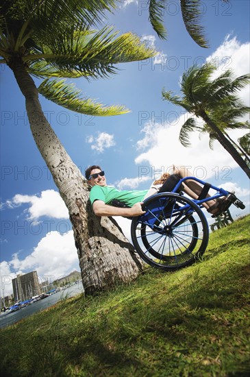 Disabled man playing in wheelchair on beach