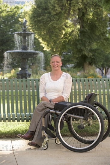 Disabled woman with wheelchair sitting on bench