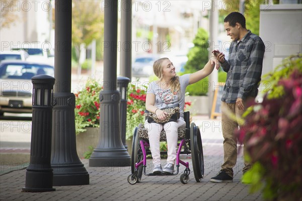 Couple using cell phone on city sidewalk