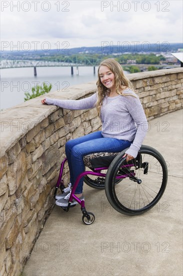 Caucasian disabled girl in wheelchair overlooking Columbus cityscape