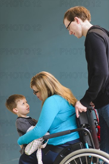 Man pushing paraplegic wife and son