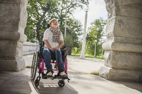 Paraplegic woman in wheelchair under stone arch