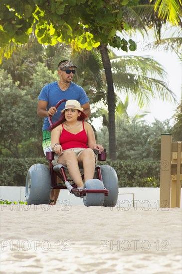 Man pushing paraplegic girlfriend in wheelchair