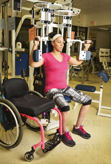 Paraplegic woman working out in physical therapy