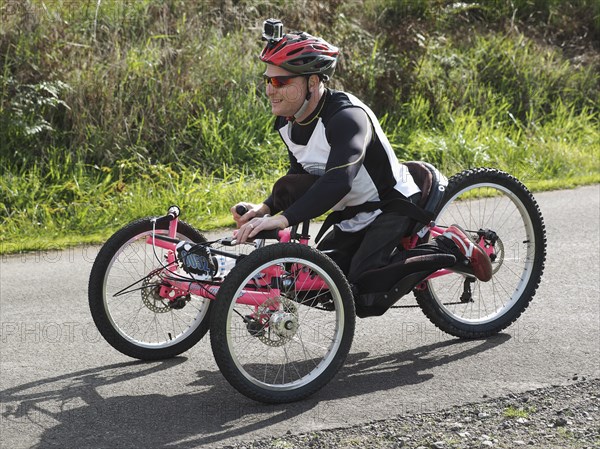 Man riding modified bicycles on rural road