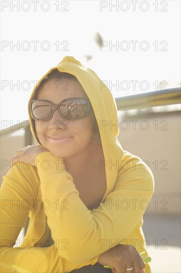 Mixed race woman in sunglasses and hoody