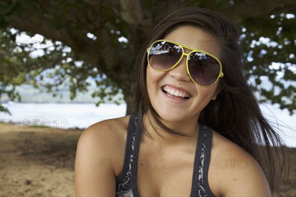 Smiling mixed race teenager in sunglasses