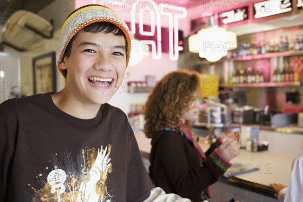 Mixed race boy smiling in cafe