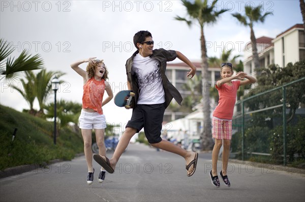 Friends jumping on urban sidewalk