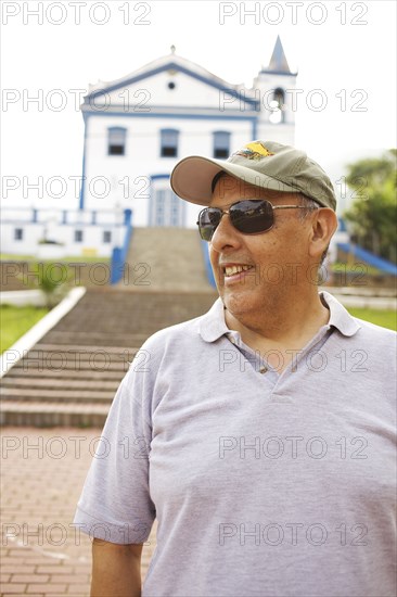 Hispanic tourist standing near church