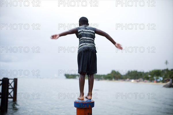 Boy on pipe about to jump in the water