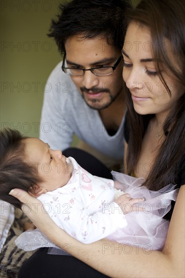 Mother and father looking at newborn baby