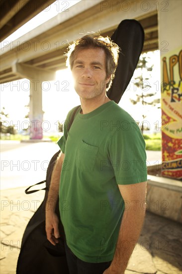 Smiling Caucasian man carrying double bass