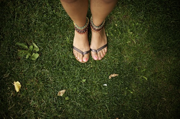 Hispanic woman wearing anklets and sandals