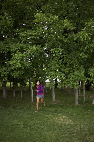 Hispanic woman running through park