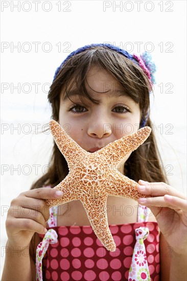 Hispanic girl holding starfish