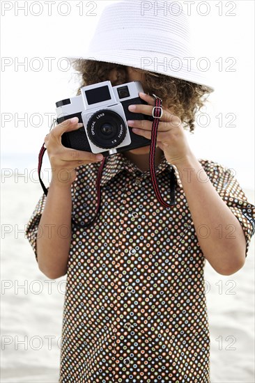 Mixed race boy using old-fashioned camera