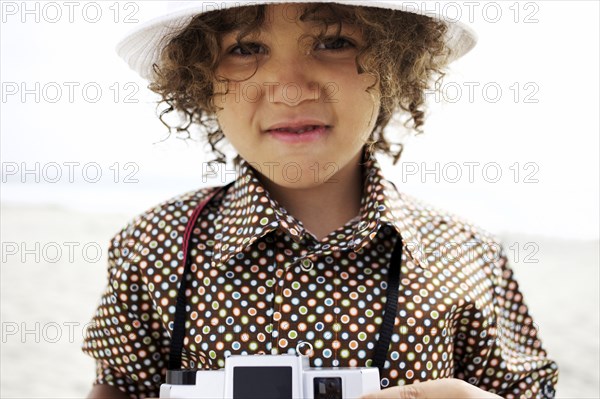 Mixed race boy using old-fashioned camera