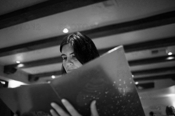 Caucasian woman reading menu in restaurant