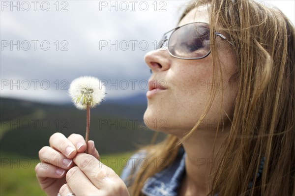 Woman glowing dandelion puff