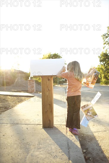 Caucasian man throwing mail out of mailbox
