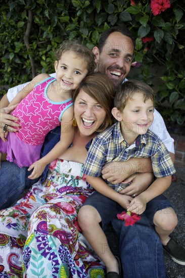 Laughing parents holding children on lap