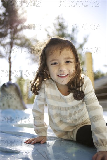 Mixed race girl sitting outdoors