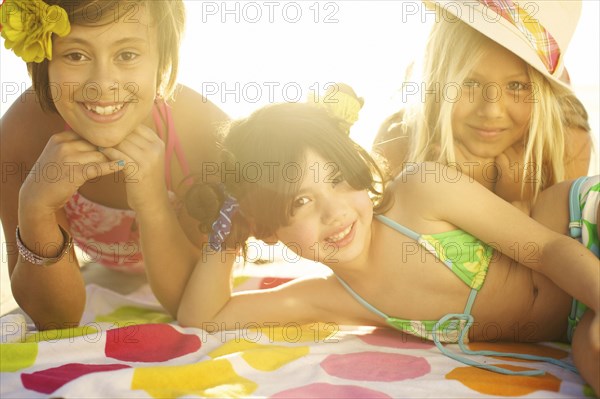 Children in bikinis laying on towel