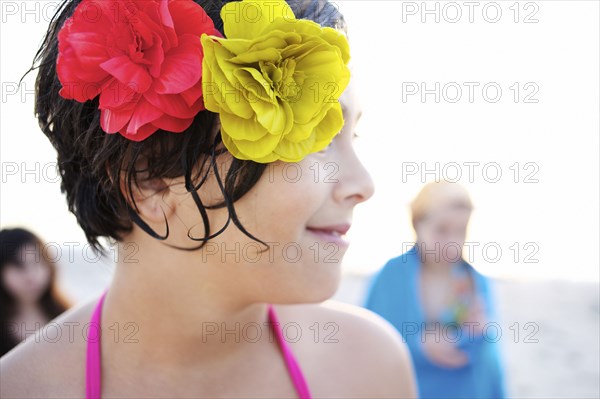 Mixed race girl on beach with flowers in her hair