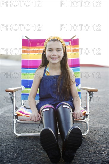 Mixed race girl sitting in lounge chair