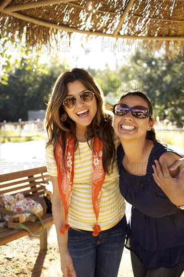 Smiling mixed race sisters hugging