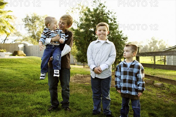 Caucasian brothers standing in yard