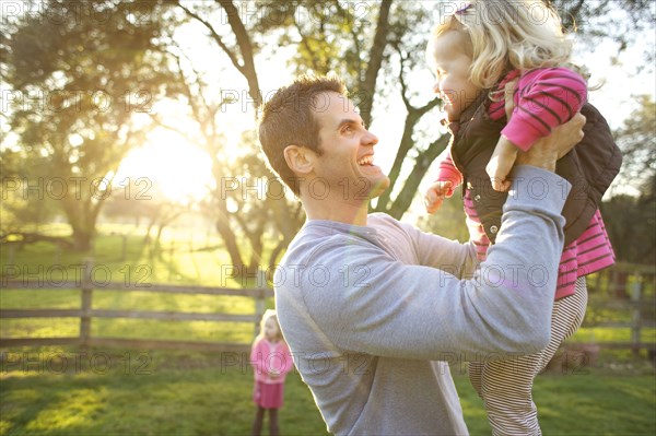 Caucasian father lifting daughter