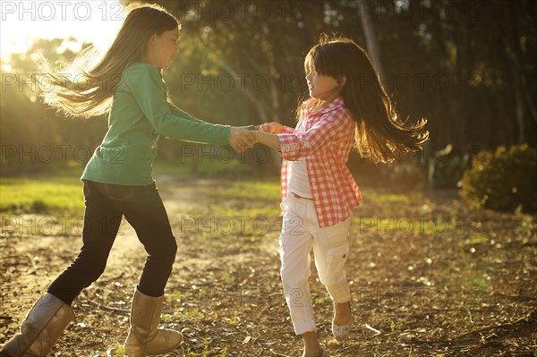 Mixed race sisters dancing in circle together