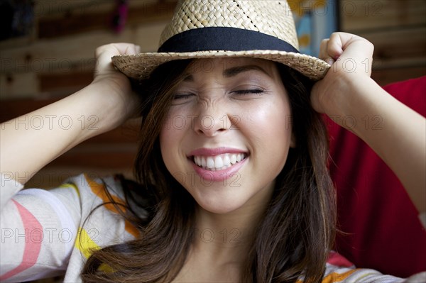 Mixed race woman putting on hat