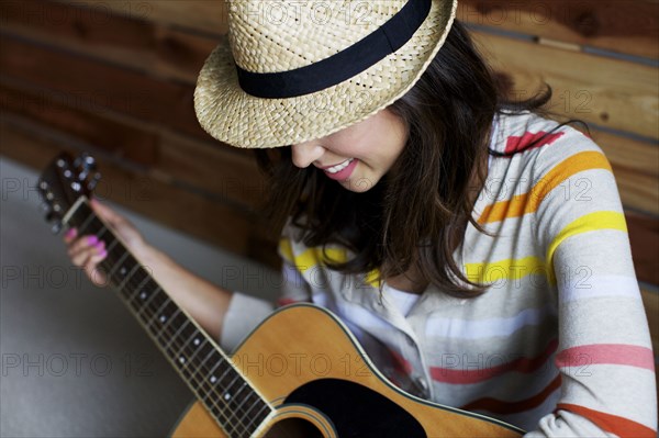 Mixed race woman playing guitar