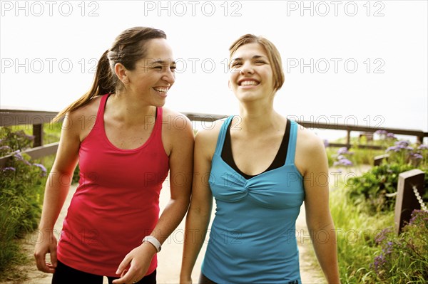 Laughing athletic friends standing together outdoors