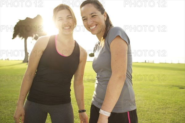 Smiling athletic friends standing together in field
