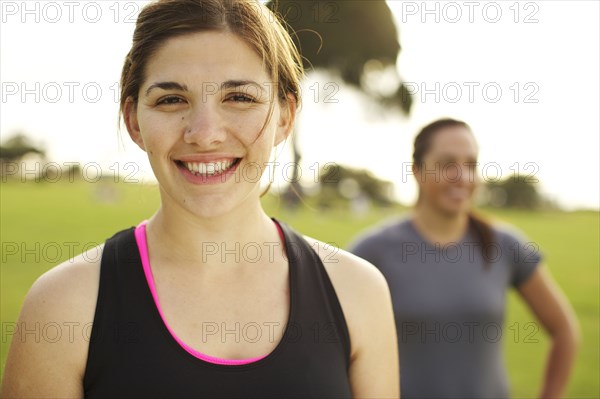Smiling athletic friends standing together in field