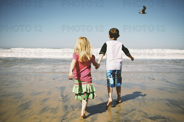 Children walking together on beach