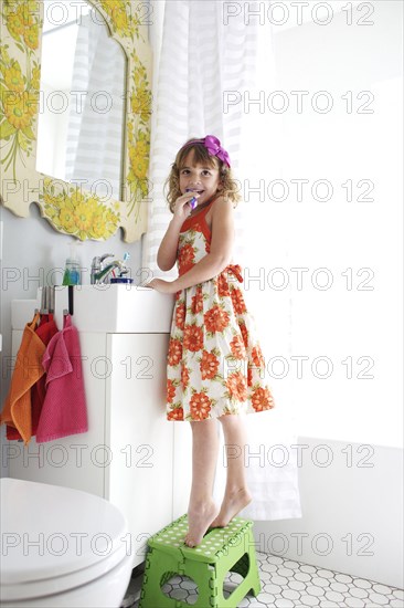 Mixed race girl brushing her teeth